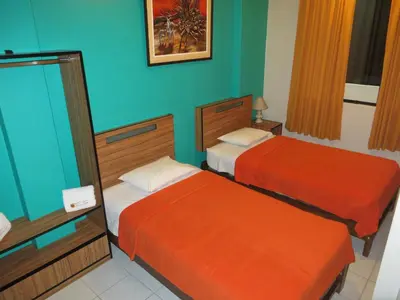 two beds in a room with blue and orange at Hostal Hellen Ross in Nazca