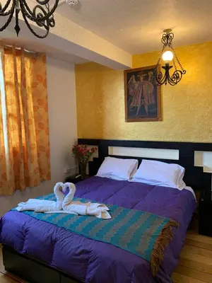 a bedroom with a bed with a towel on it at Qolqampata Hotel in Cusco