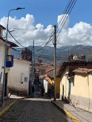 a cobblestone street in a town with buildings at Qolqampata Hotel in Cusco