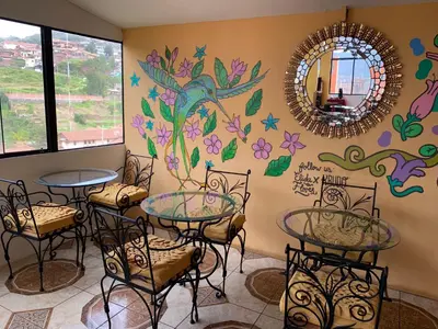 a room with tables and chairs and a mirror at Qolqampata Hotel in Cusco