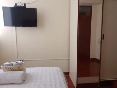 a room with a bed and a television on a wall at Runawasi Caribe, Lima centric 2BDR, 20 min from airport in Lima