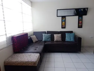 a couch and a chair in a room at Runawasi Caribe, Lima centric 2BDR, 20 min from airport in Lima