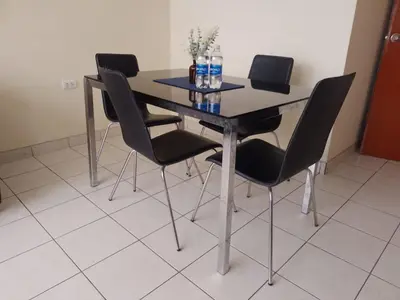 a dining room table with black chairs and bottles of water at Runawasi Caribe, Lima centric 2BDR, 20 min from airport in Lima