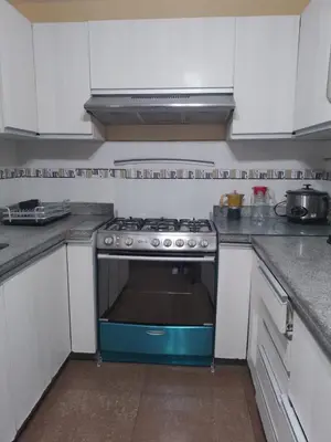 a kitchen with a blue stove and white cabinets at Runawasi Caribe, Lima centric 2BDR, 20 min from airport in Lima