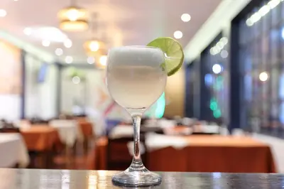 a glass with a lime on top of a table at Hotel Casa Campesina in Cusco
