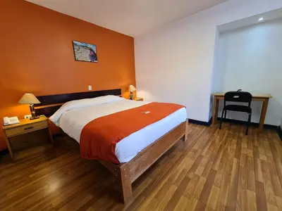 a bedroom with a bed and a desk and a chair at Hotel Casa Campesina in Cusco