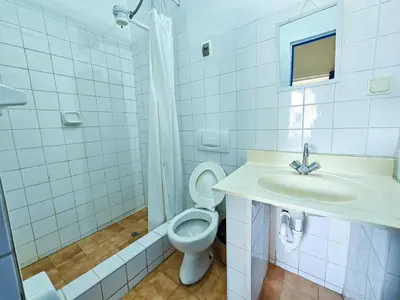 a white bathroom with a sink and a toilet at Hospedaje Euro's De San Blas in Cusco
