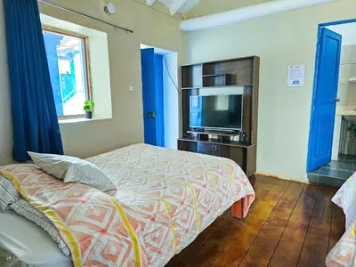 a bedroom with a bed and a flat screen tv at Hospedaje Euro's De San Blas in Cusco