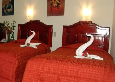 two beds with swans on them in a bedroom at Hotel Inkayra in Cusco