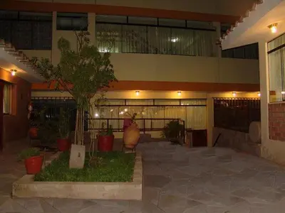 a building with a large vase and plants in a courtyard at Hotel Inkayra in Cusco
