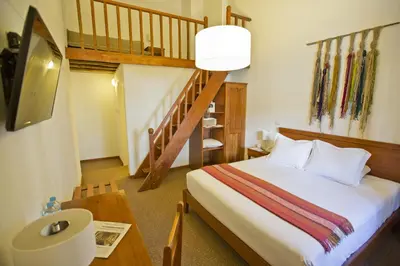 a bedroom with a bed and a spiral staircase at Tierra Viva Cusco Centro in Cusco