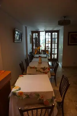 a group of tables in a room with chairs at Hostal Camiluz in Nazca