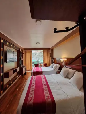 a hotel room with two beds and a large window at Hs Tierra In in Machu Picchu