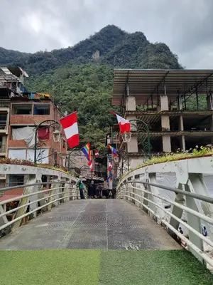 a bridge with flags on the side of a mountain at Hs Tierra In in Machu Picchu