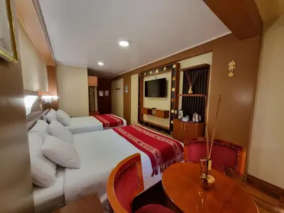 a hotel room with two beds and a table at Hs Tierra In in Machu Picchu