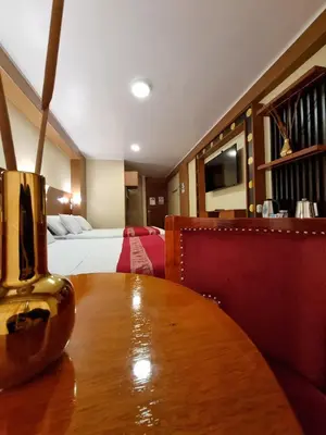 a room with a wooden table and a bed at Hs Tierra In in Machu Picchu