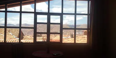 a window with a view of a city at Kuska Hostal in Cusco