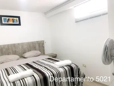 a bedroom with a bed with a striped blanket at Departamento Miraflores in Lima