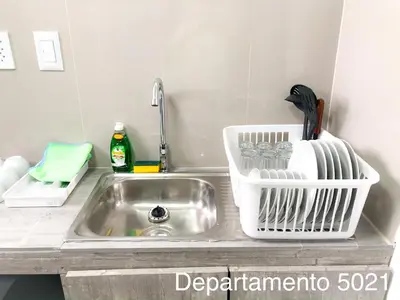 a kitchen sink with a dish drying rack next to it at Departamento Miraflores in Lima