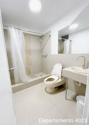 a white bathroom with a toilet and a sink at Departamento Miraflores in Lima