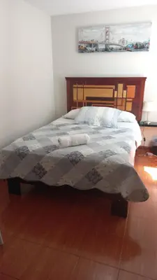 a bedroom with a bed with a quilt on it at CASA LOPEZ in Lima