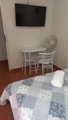a bedroom with a bed and a table and a tv at CASA LOPEZ in Lima