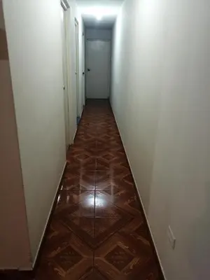 a long hallway with a wooden floor and white walls at CASA LOPEZ in Lima
