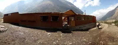 a small building in the middle of a mountain at Soraypampa Hostel - Private Cabins & Dorms for Self-Guided Humantay & Salkantay Trek -Comidas-hot shower-wifi-Pack horses in Salcantay