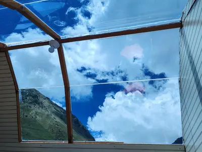 a window in a house looking at the sky at Soraypampa Hostel - Private Cabins & Dorms for Self-Guided Humantay & Salkantay Trek -Comidas-hot shower-wifi-Pack horses in Salcantay