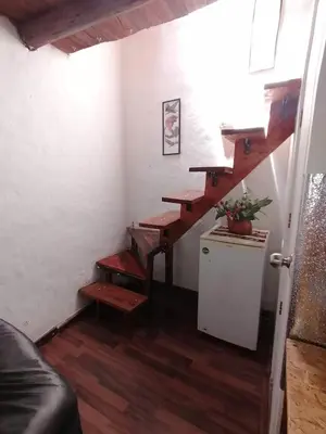 a stairway in a living room with wooden stairs at Asiriq Wasi Guest House in Cusco
