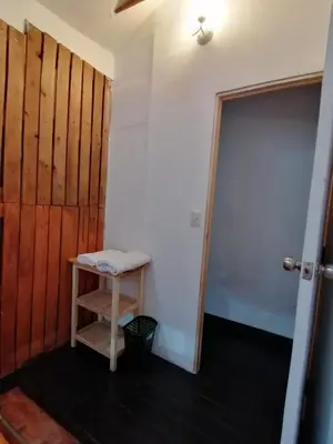 a room with a door and a stool next to a door at Asiriq Wasi Guest House in Cusco