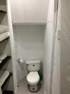 a small bathroom with a white toilet and towels at Asiriq Wasi Guest House in Cusco