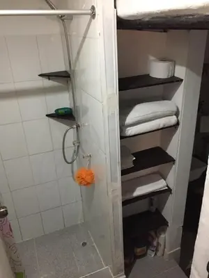 a shower with a glass door with towels in a bathroom at Asiriq Wasi Guest House in Cusco