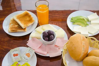 a table with plates of food and a glass of orange juice at Martinika in Lima