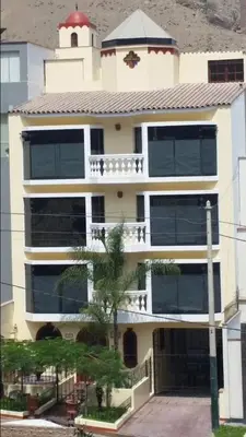 a large white building with a balcony and a palm tree at Entire Studio-Penthouse De Luxe in Lima