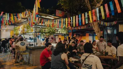 a group of people sitting at a bar with flags at Viajero Lima - Barranco Hostel in Lima