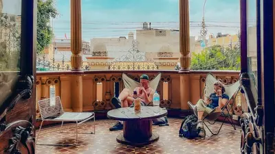 two women sitting in chairs on a balcony at Viajero Lima - Barranco Hostel in Lima