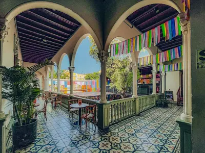 an outdoor patio with tables and chairs and colorful flags at Viajero Lima - Barranco Hostel in Lima