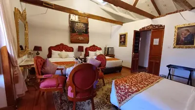 a bedroom with two beds and a table and chairs at Casona Corrales Hotel Boutique in Cusco