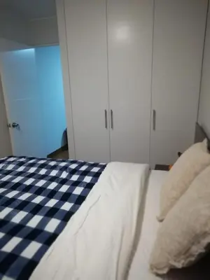 a bedroom with a checkeredkered bed and white cabinets at Hope San Isidro in Lima