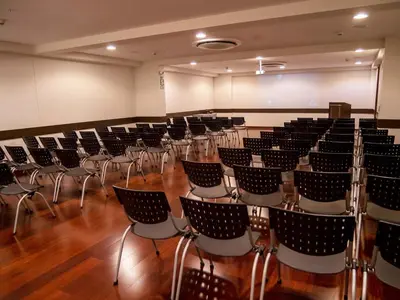 a room with rows of chairs and a projection screen at Hotel Britania Crystal Collection in Lima