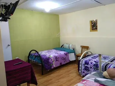 a room with two beds and a table in it at Hotel Sueños del Chuncho in Yauyos