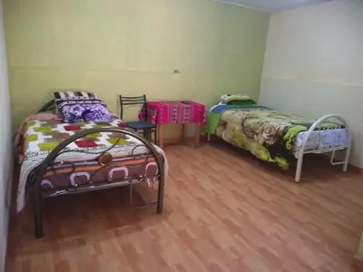 two beds sitting in a room with wooden floors at Hotel Sueños del Chuncho in Yauyos