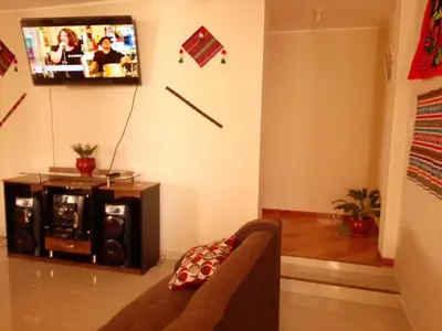 a living room with a couch and a tv at Marlon's House Nasca in Nazca