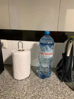 a bottle of water on a counter next to a roll of toilet paper at MLA Apartments - Alcanfores in Lima