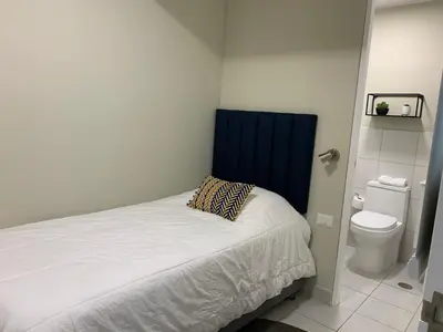 a small bedroom with a bed and a toilet at MLA Apartments - Alcanfores in Lima
