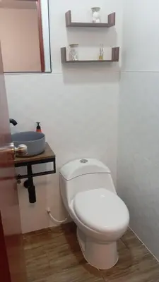 a bathroom with a white toilet and a sink at Chakana Family Home Lima Airport in Lima
