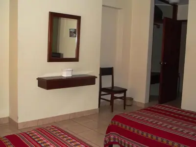 a room with a mirror and a bed and a chair at Hostal Gemina in Lima