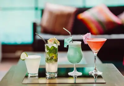 a group of four different cocktails on a table at Nativus Hostel Machu Picchu in Machu Picchu
