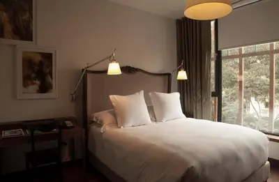 a bedroom with a bed with two pillows and a window at Hotel B in Lima
